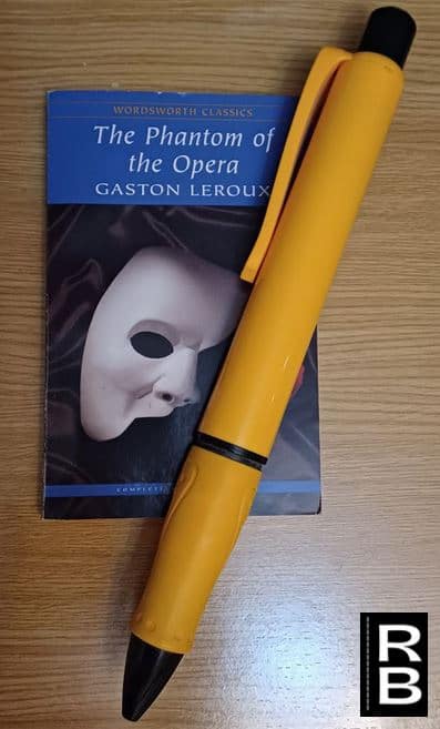Huge yellow pen compared to a book.