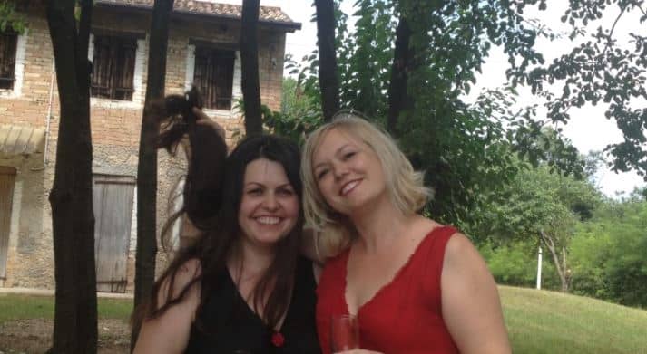 Rebeca Duriga and one of her sisters, with a nice house behind them.