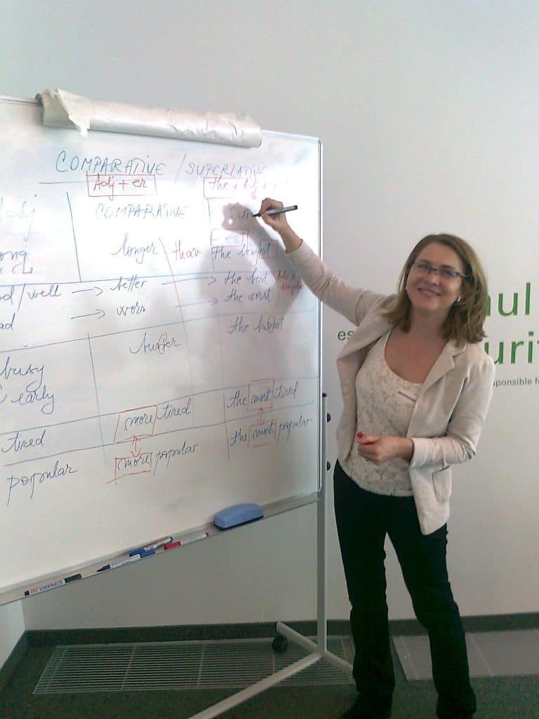 One of Rebeca Duriga's students is smiling and holding a pen up to a board.