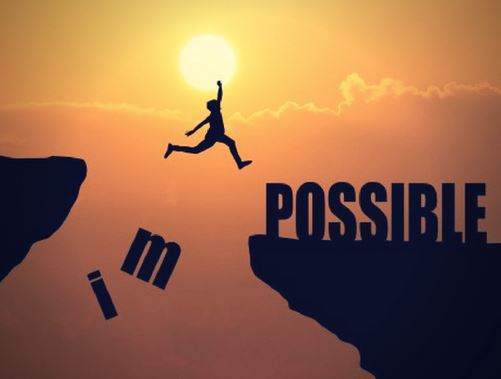 A person jumping from one cliff to another, the letters I and M, part of the word "impossible" falling to the ground as a result. One the second cliff there is only the word "possible."