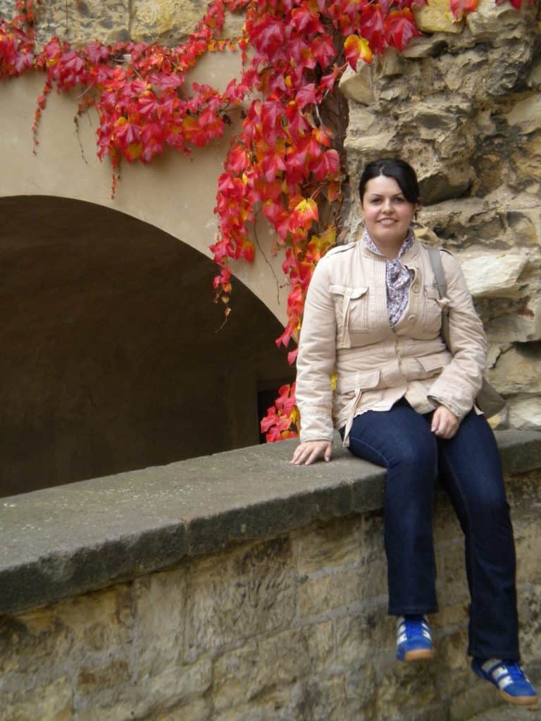 Rebeca Duriga sitting in front of a beautiful bridge.