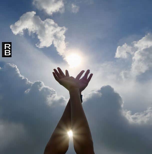 Two hands reaching up to the sky, in a gesture of letting go.
